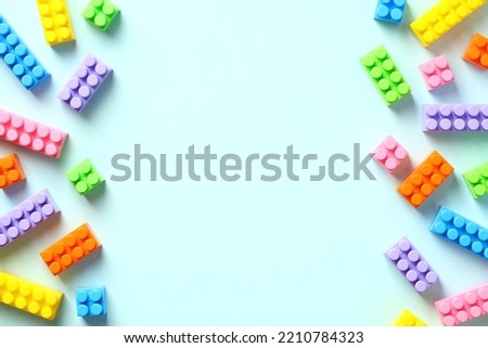 Frame of lego building block toys on pastel blue background. Banner for kids toys shop. Flat lay, top view, copy space.