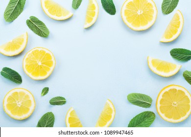 Frame From Lemon Slices And Mint Leaves On Blue Pastel Table Top View. Ingredients For Summer Drink And Lemonade. Flat Lay Style.