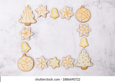 Frame made of Christmas gingerbread cookies on white background with copy space. Cookies of various shapes in sugar glaze. Snowflake, star, bell, ball, Christmas tree. Top view. - Powered by Shutterstock