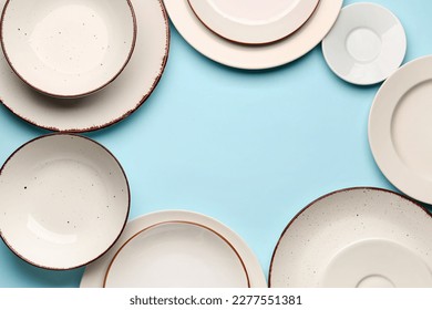 Frame made of plates and bowls on blue background - Shutterstock ID 2277551381