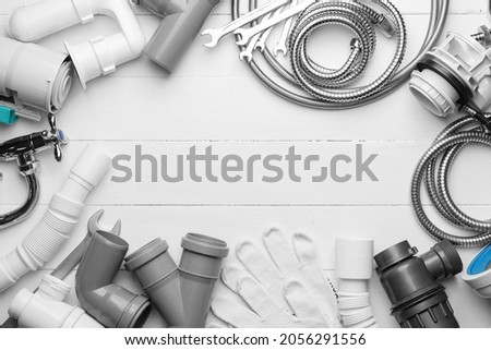 Frame made of plumber's items on light wooden background