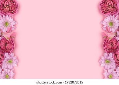 Frame made of rose and aster flowers on a pink background with copyspace. Springtime concept. 