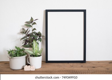 Frame poster with tropical leaf plant in pot on table.lifestyle home decor