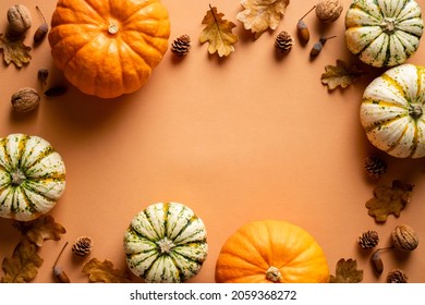 Frame Of Ripe Pumpkins, Dry Oak Leaves, Acorns, Pine Cones On Orange Background. Thanksgiving Day Banner Mockup.