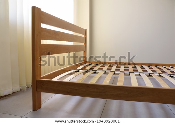 frame\
of a simple lacquered bed made of wood with\
slats