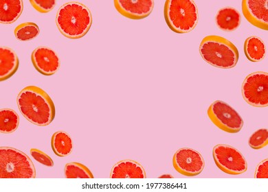 Frame of sliced fresh grapefruit isolated on light pink background. Vitamins, healthy diet and detox concept. Sliced grapefruit floating in the air. 