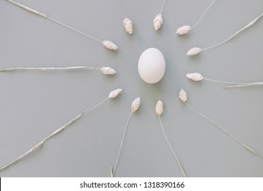Frame of spikelets with egg in the centre on gray background. Easter holiday concept. Space for text, top view, flat lay. - Shutterstock ID 1318390166