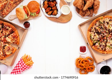 Frame with a variety of take out and fast foods. Pizza, hamburgers, fried chicken and sides. Top view on a white wood background with copy space. - Shutterstock ID 1774690916
