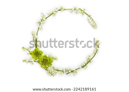 Frame with white flowers Lily of the valley ( Convallaria majalis, May bells, may-lily ), hellebores on white background with space for text. Top view, flat lay