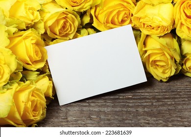 Frame with yellow roses on old wooden background