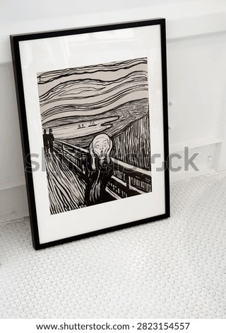 Framed artwork The Scream by Edvard Munch, displayed on a textured floor.