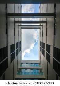 Framed clouds in the sky view surrounded by condominium apartment building architecture viewed from below