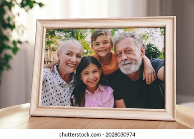 Framed Family Photo On Wooden Table In Room