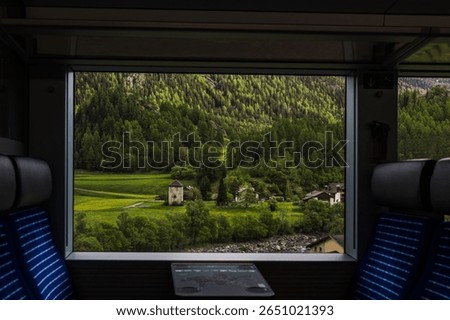 Framed view from a train window of a quiet alpine valley