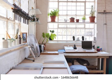 Frames being assembled on a workbench with the office area of a picture framing workshop in the background - Shutterstock ID 1648636648
