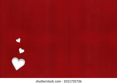 Frames of white hearts on a red wooden background