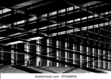 Framework Of Modern Building. Backlit Metal Supporting Structures In Darkness. Grunge Photo Of Industrial Architecture Fragment. Construction Industry. Abstract Black And White Grid Background.