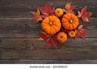 Framework with pumpkins and fall leaves on wooden background. Top view.