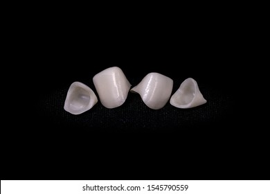 Frameworks of ceramic crowns. Zirconia crowns. Metal-free ceramics at the manufacturing stage. Close-up, black isolate.