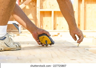 Framing Contractor Measuring And  Chalk Line To Install Plywood Sub Siding To Wood Joist