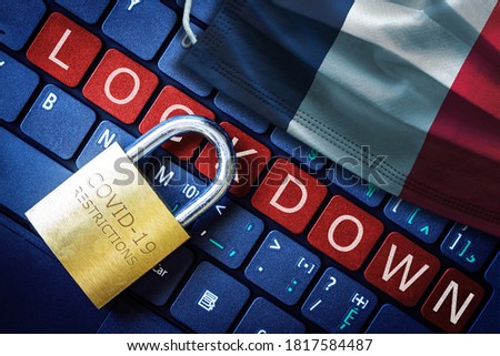 France COVID-19 coronavirus lockdown restrictions concept illustrated by padlock on laptop red alert keyboard buttons and face mask with French flag.