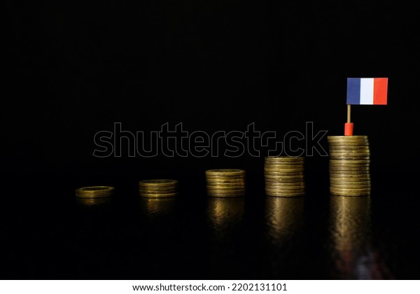 France economic growth, recovery\
after financial crisis and currency appreciation concept. French\
flag in increasing stack of coins in dark black\
background.