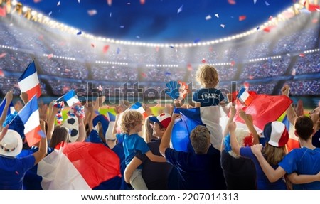 France football supporter on stadium. French fan group on soccer pitch watching winner team play. Crowd with national flag and jersey cheering for France win. Championship game