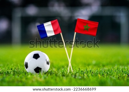 France - Morocco. Semifinals. football match. Last four. Handmade national flags and soccer ball on green grass. Football stadium in background. Black edit space.