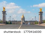 France. Sunny summer day in Paris and facade of the Esplanade Invalides. Cars and people on the bridge of Alexander III