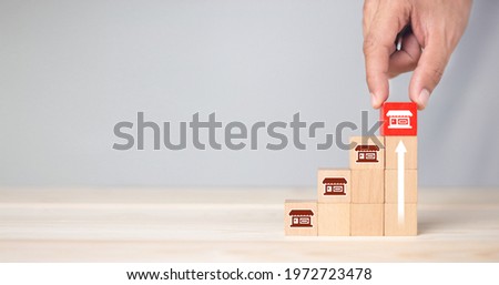 Franchise business,Businessman hand choose wooden blog with franchise marketing icons Store. Franchise business concept. Foto stock © 