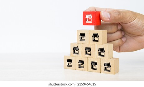 Franchise, Close-up hand choose cube wooden toy block stack with franchises business store icon for franchising business marketing plan to growth and branch expansion and banking loan. - Shutterstock ID 2153464815