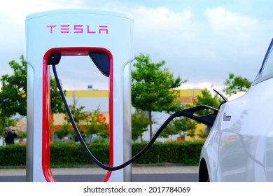 FRANKFURT, Germany - August 2021: Tesla cars of the American company Elon Musk, electric vehicle manufacturer, fill the battery at TESLA Supercharger, electric energy storage concept