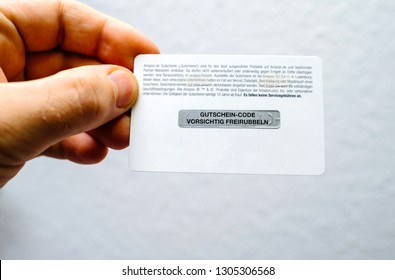 Frankfurt, Germany - Dec 28, 2018: Man Hand Holding Rear Part Of An Amazon Gift Card With Untouched Scratch Part