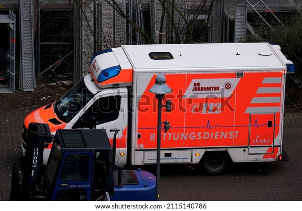 Frankfurt, Germany - January 2022: modern Red\
paramedic ambulance emergency service vehicle, medics provide\
assistance at construction site, concept of accident at work,\
violation labor\
protection