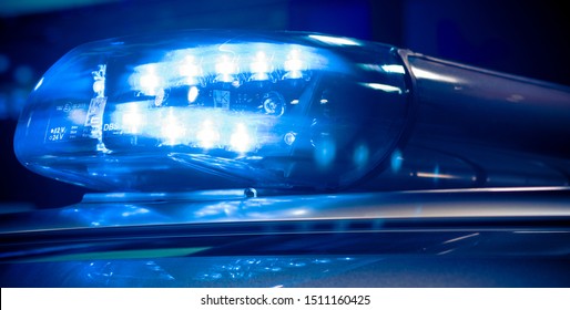 Frankfurt am Main, Germany - September 20 2019: Police at night in the car with blue siren flasher. Siren on police car flashing, close-up in Frankfurt, Germany.