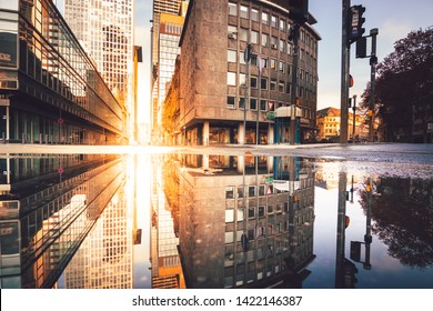 Frankfurt in the morning, looking into a street canyon with sunlight and reflection in a puddle on the street - Powered by Shutterstock