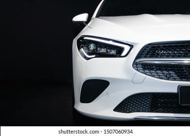 FRANKFURT - SEP 15, 2019: white Mercedes-Benz CLA 200 Shooting Brake at IAA 2019 International Motor Show, compact luxury car. Close-up of front and headlight of the white car on black background