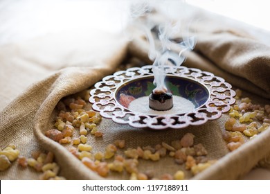 Frankincense burning on a hot coal. Frankincense is an aromatic resin, used for religious rites, incense and perfumes, incense smoke