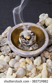 Frankincense burning on a hot coal. Frankincense  is an aromatic resin, used  for religious rites, incense and perfumes.