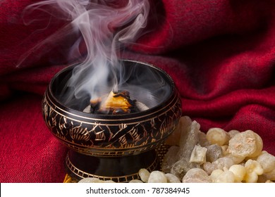 Frankincense brennt auf einer heißen Kohle.Frankincense ist ein aromatisches Harz, das für religiöse Riten, Räucherstäbchen und Parfums verwendet wird.