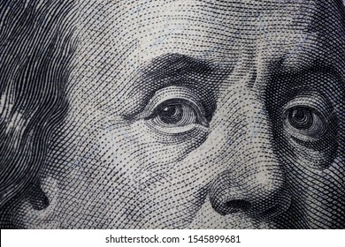 Franklin eyes macro. The texture of the fragment of the dollar bill. USD banknote texture. One hundred American dollars. Can  inform about fiscal and monetary policy of the country, currency inflati