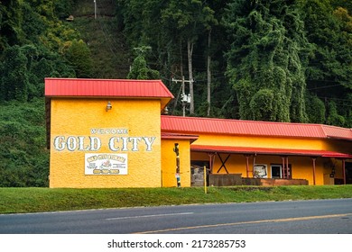 Franklin, USA - October 6, 2021: North Carolina city in Blue Ridge mountains with sign for Gold City welcome and storage building exterior for Gem Mine Amusement in yellow color