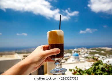 Frappe cold coffee in a hand on Santorini island in Greece.