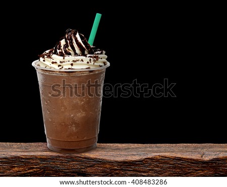 Frappuccino in take away cup on wooden table isolated on black