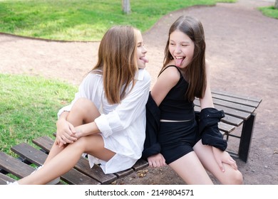 Fraternal Twins Sisters. Blonde And Brunette Teen Girls In Fashionable Black And White Clothes Outdoors. Sisterhood, Siblings Spending Time Together