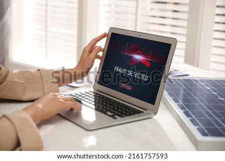 Fraud prevention security system. Woman using laptop at white table, closeup
