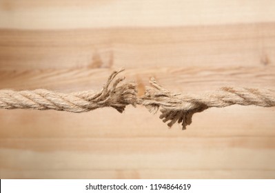 Frayed Rope At Breaking Point On Wooden Background