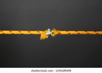 Frayed Rope At Breaking Point On Gray Background