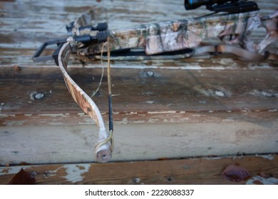A frayed, worn out, broken bowstring that will need to be replaced.  This is general maintenance on compound and crossbows, and is very important to keep in good repair. Shallow depth of field.