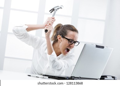 Freaked Out Business Woman With A Hammer Ready To Smash Her Laptop Computer